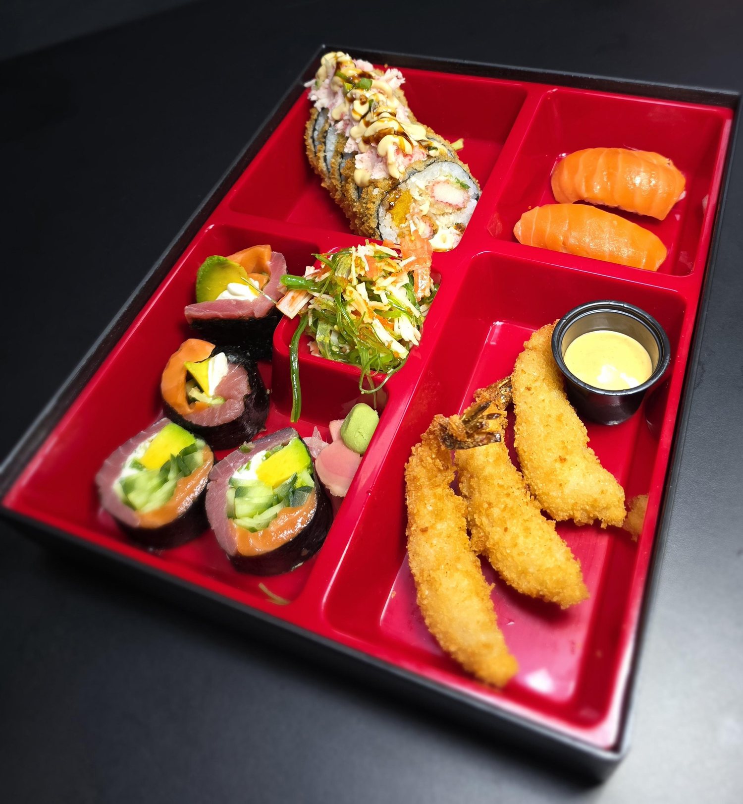 Bento box rojo con rollos, nigiris y camarones empanizados